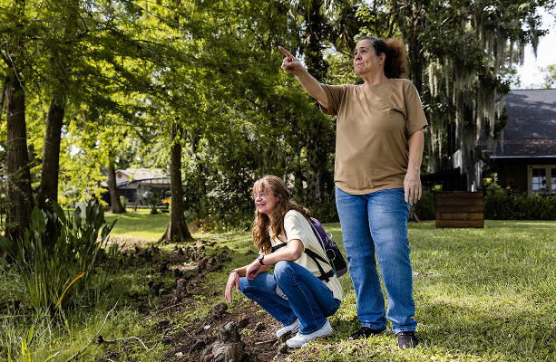 Nicole and joint outside pointing at something in the distance while smiling