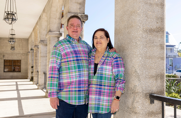 Nayda and her husband Nathan smiling by some pillars outdoors