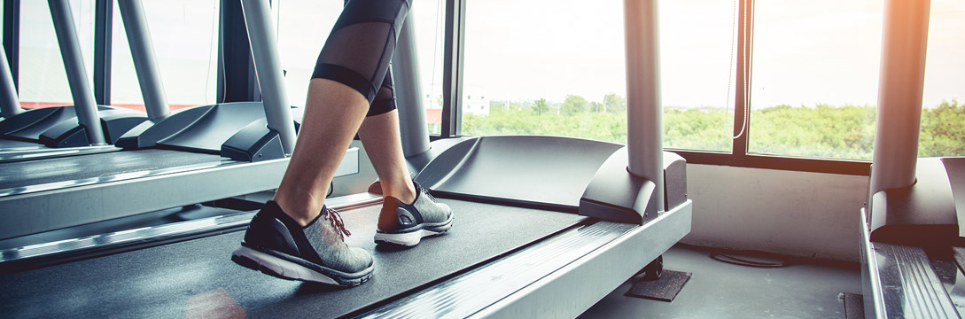 A woman getting started on a treadmill during an exercise program